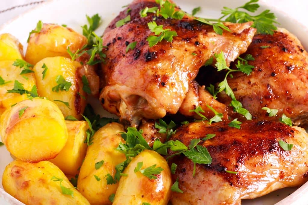 Refeição prática: coxas de frango com batatas e coentro receita prática e tradicional com especiarias e temperos deliciosos.