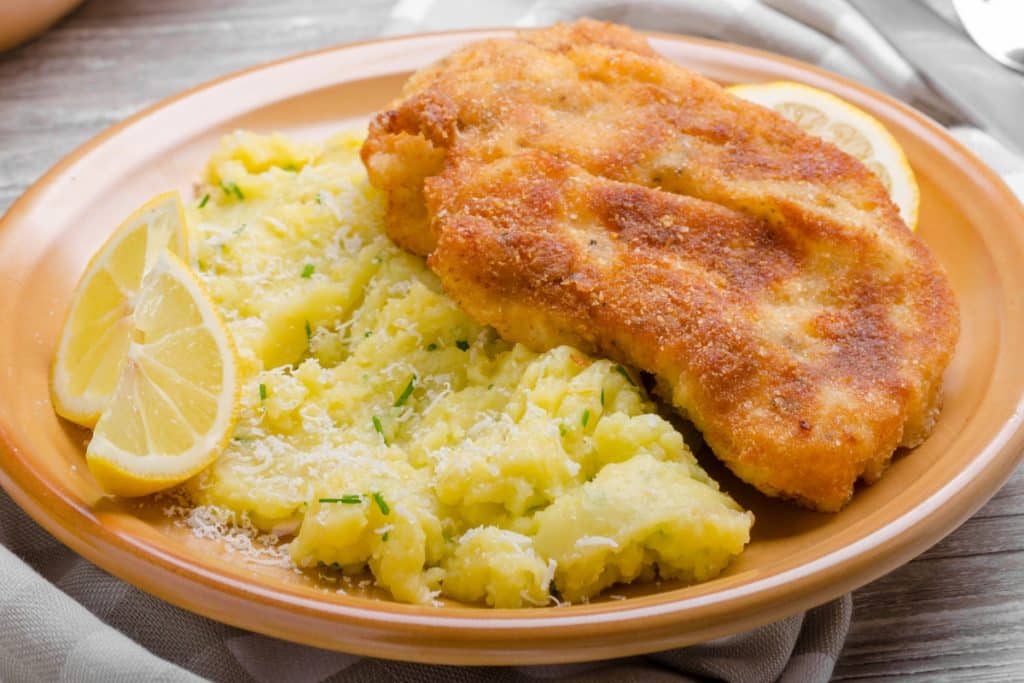 Schnitzel com crosta crocante de parmesão e purê de batata cremoso com parmesão